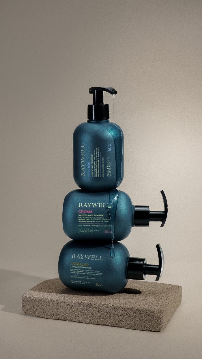Три шампуні Raywell складені стопкою на бетонній підставці
